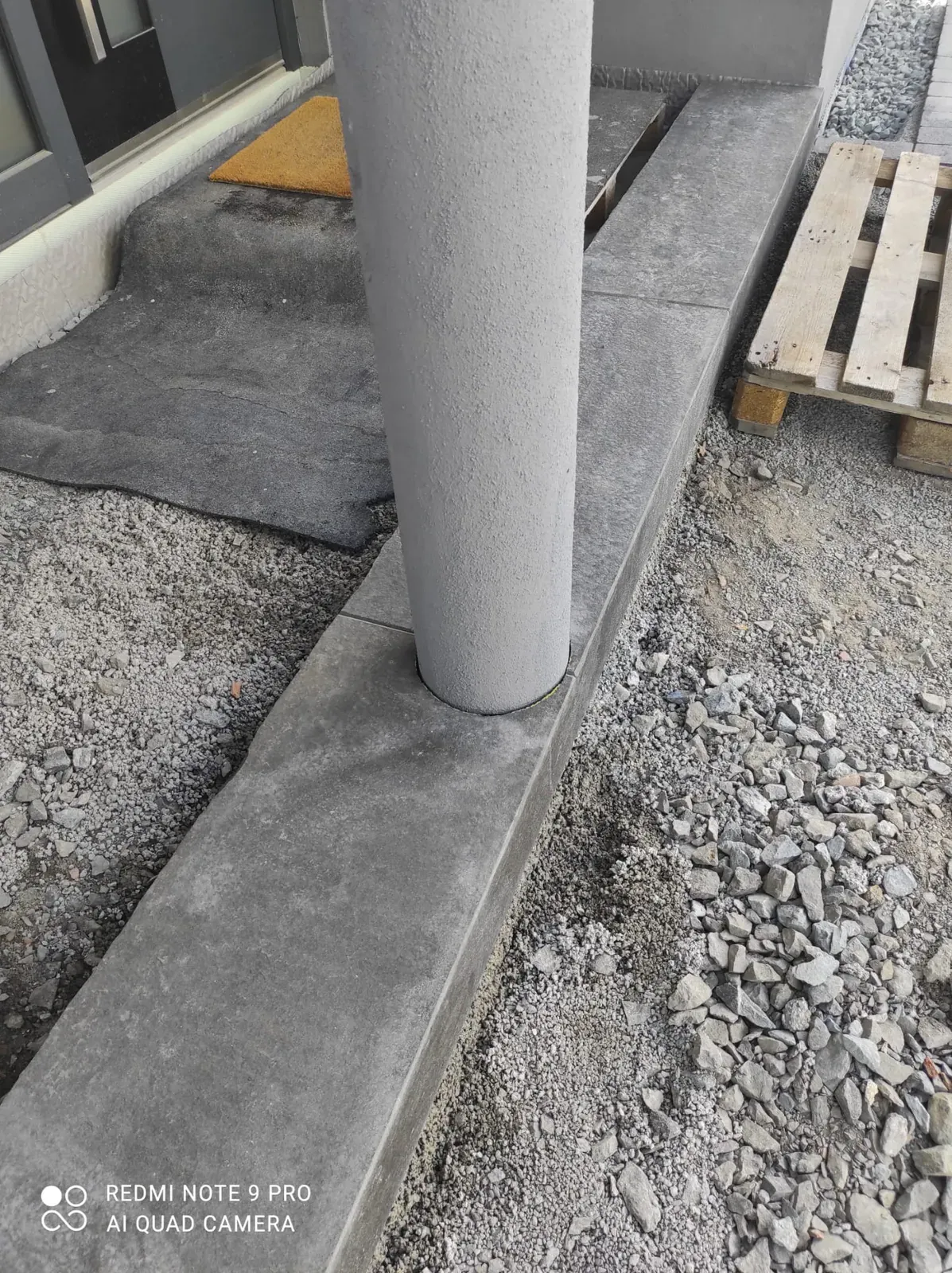 Detailaufnahme eines sauber ausgeführten Betonfundaments im mineralischen Unterbau.