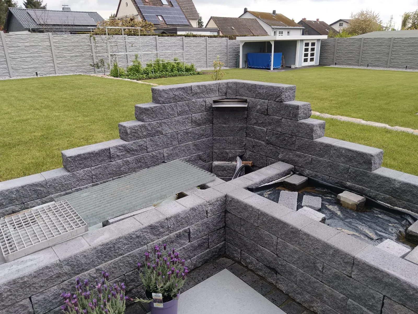 Bauphase eines rechteckigen Wasserbeckens mit gemauerten Ebenen als späterem Blickfang im Garten.